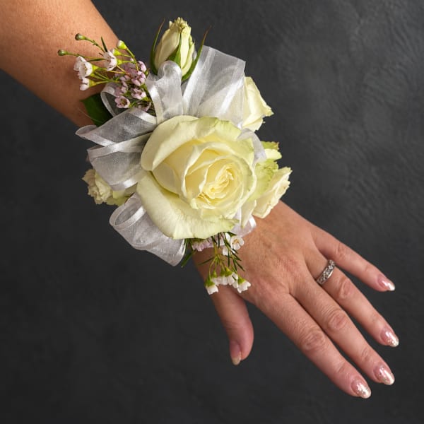 White rose wrist corsage with silver ribbon and small pink flowers