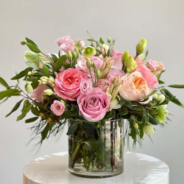 Pink and peach roses arranged in a clear glass vase