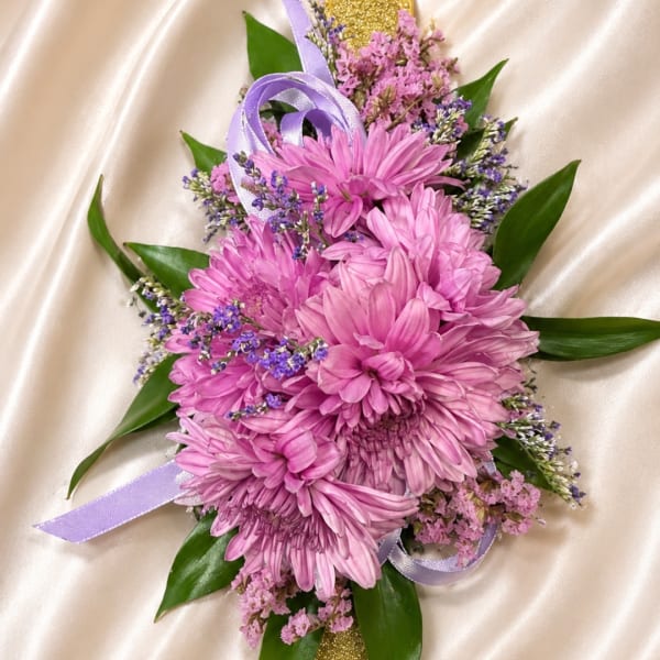 Pink chrysanthemum bouquet with purple ribbon on satin fabric