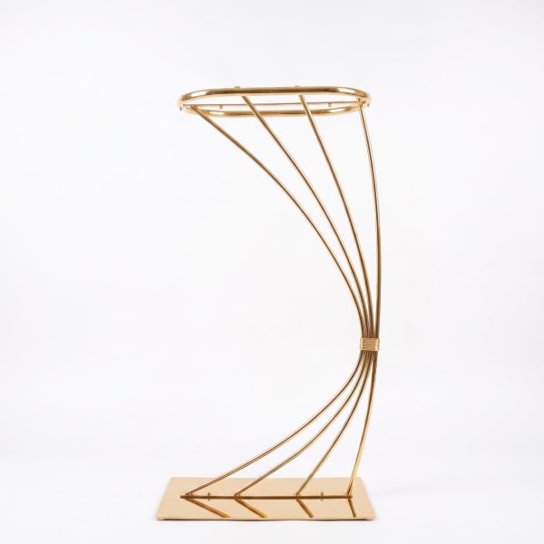 Gold metal floral stand with curved frame on a rectangular base