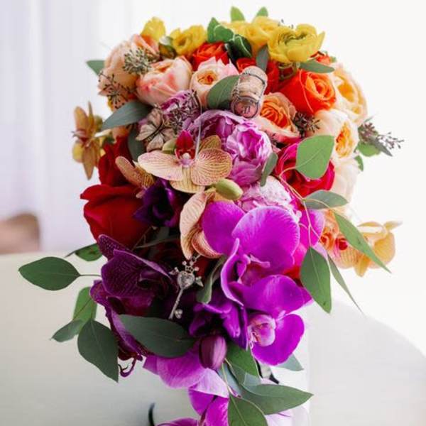 Colorful bouquet of orchids and roses with greenery