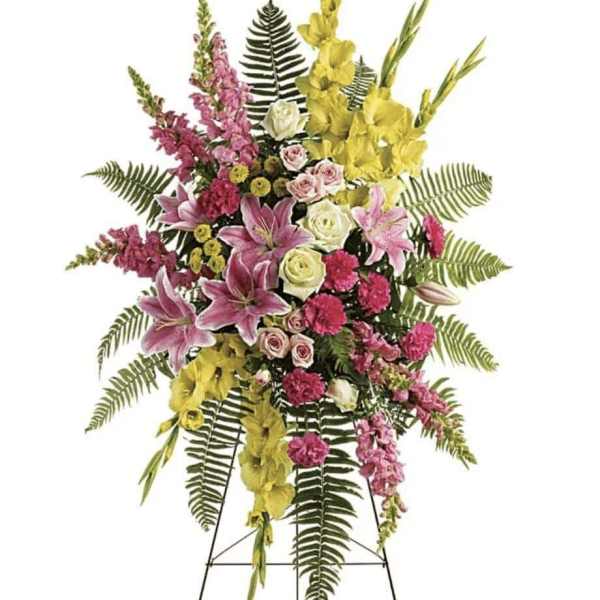 Standing floral spray with pink, yellow, and white flowers on an easel