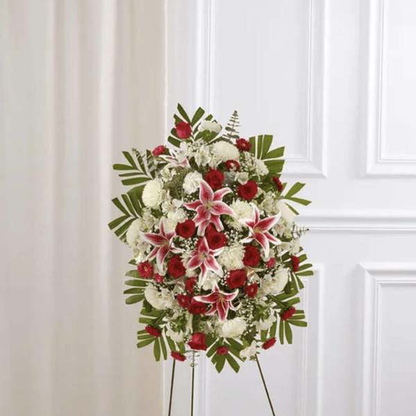 Standing floral spray with red and white flowers on an easel