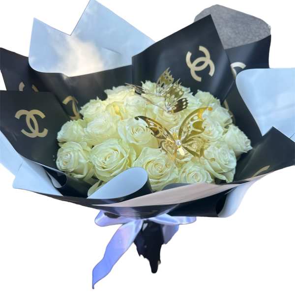 Bouquet of cream roses wrapped in black and white paper with a blue ribbon