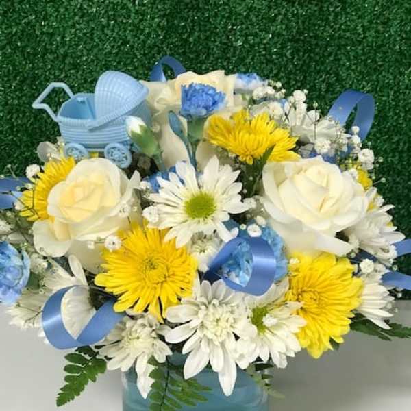 Blue and white flower arrangement in a square vase with a baby carriage decoration