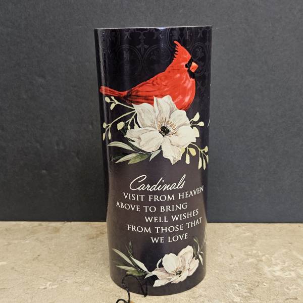 Black memorial candle holder with a red cardinal and white flowers