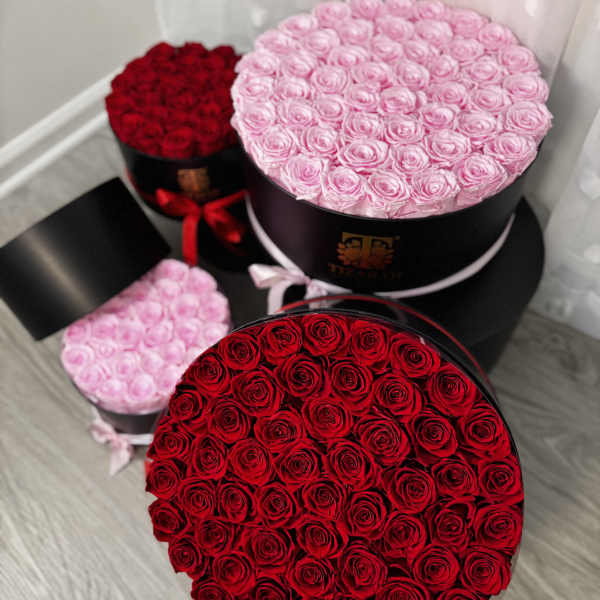 Round boxes filled with red and pink roses