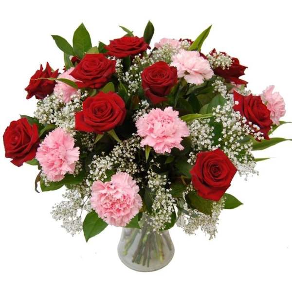 Bouquet of red roses and pink carnations in a glass vase