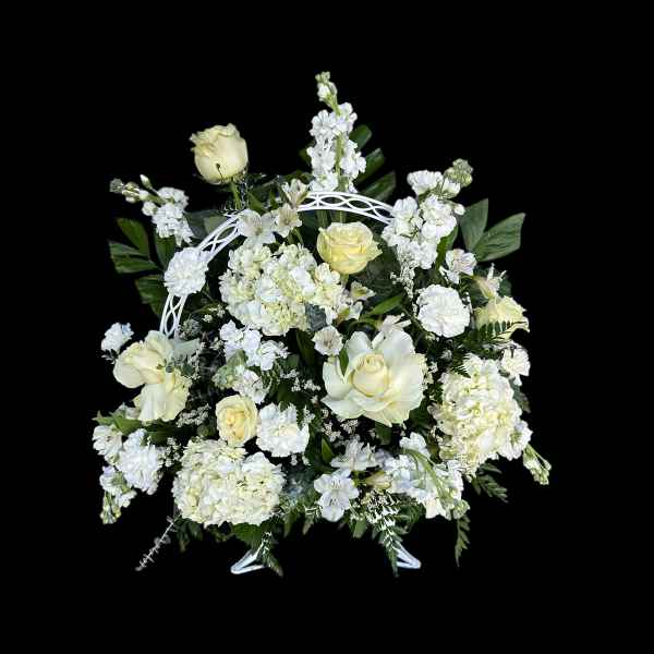 White floral arrangement with roses and hydrangeas in a white stand