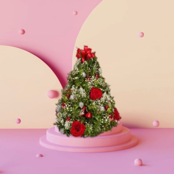 Cone-shaped floral arrangement with red roses on a pink pedestal