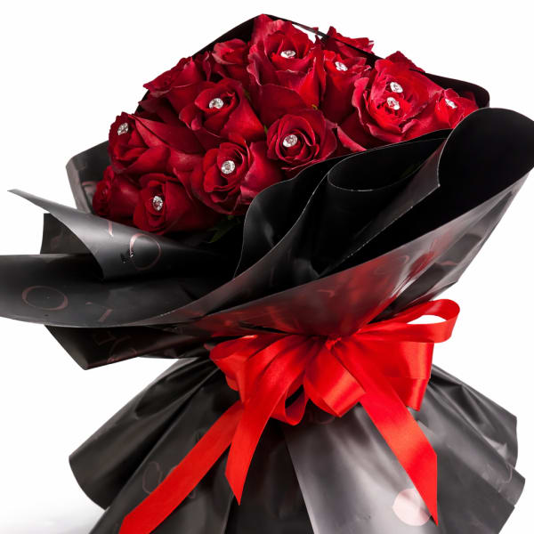 Bouquet of red roses wrapped in black paper with a red ribbon