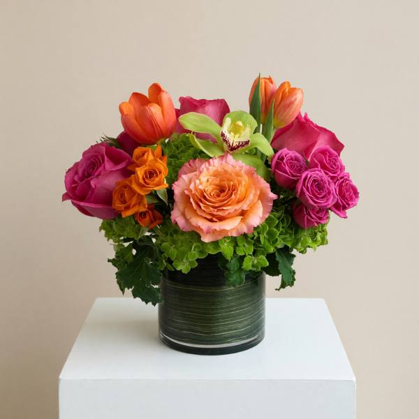 Colorful bouquet of roses and tulips in a dark green vase