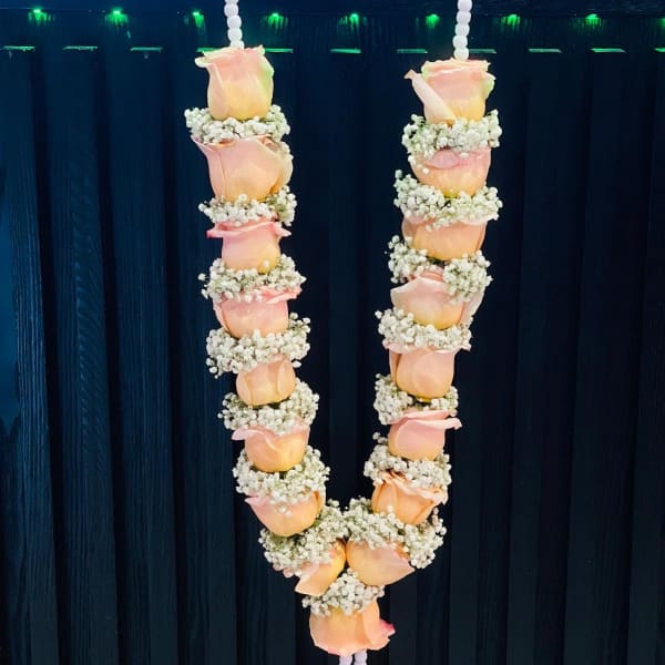 Two hanging garlands of peach roses and baby's breath