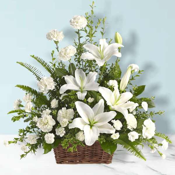 White lilies and carnations in a wicker basket