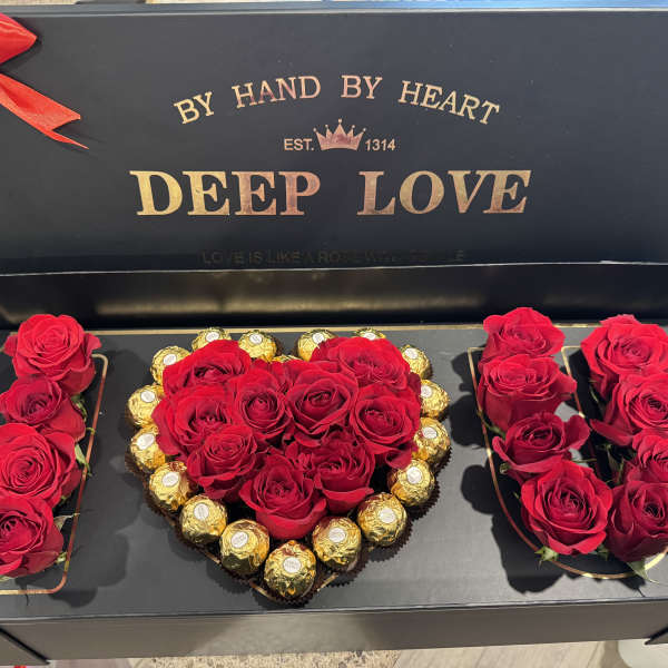 Red roses and chocolates arranged in a heart-shaped gift box