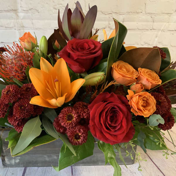 Mixed bouquet with red and orange roses, lilies, and dark mums