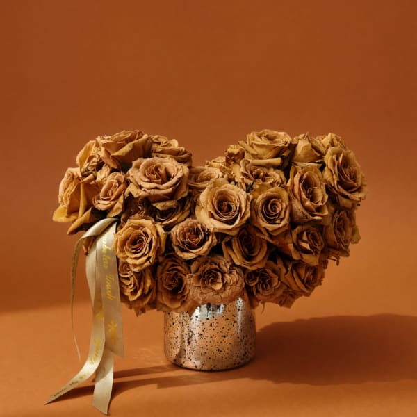 Brown rose bouquet in a speckled metallic vase with ribbon