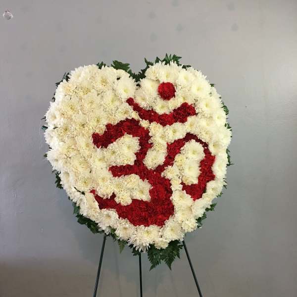 Heart-shaped floral wreath of white and red flowers on a stand