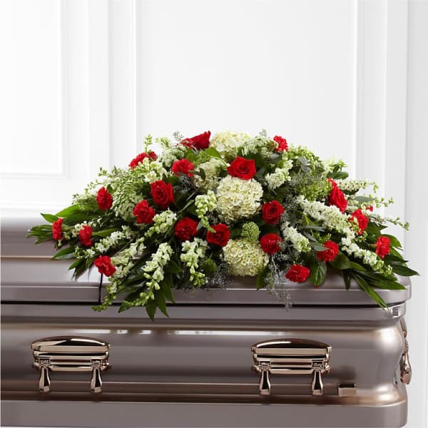 Red and white floral spray on a silver casket