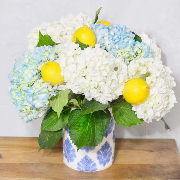 Blue and white hydrangeas with lemons in a patterned vase