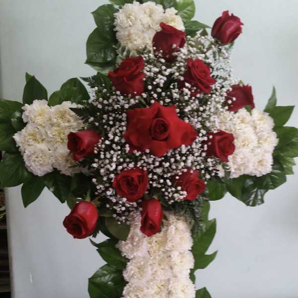 Cross-shaped floral arrangement with red roses and white flowers