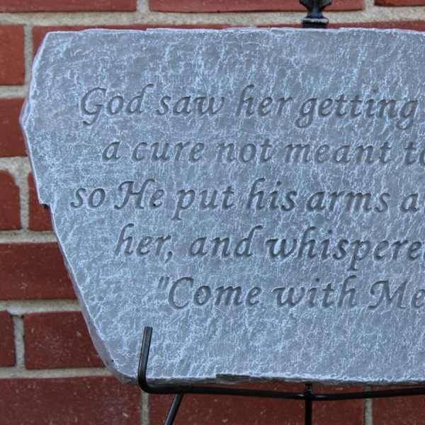 Engraved stone plaque with a religious quote on a metal stand