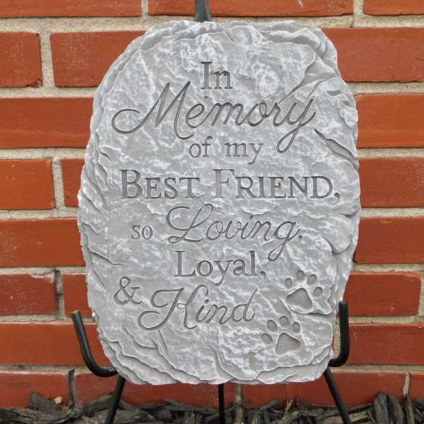 Gray memorial stone with engraved tribute text and paw prints