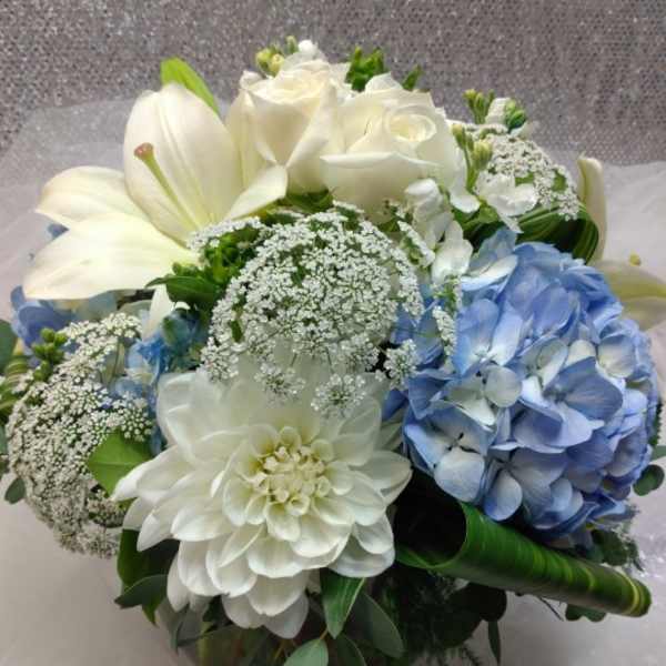 Bouquet of white roses, lilies, and blue hydrangea