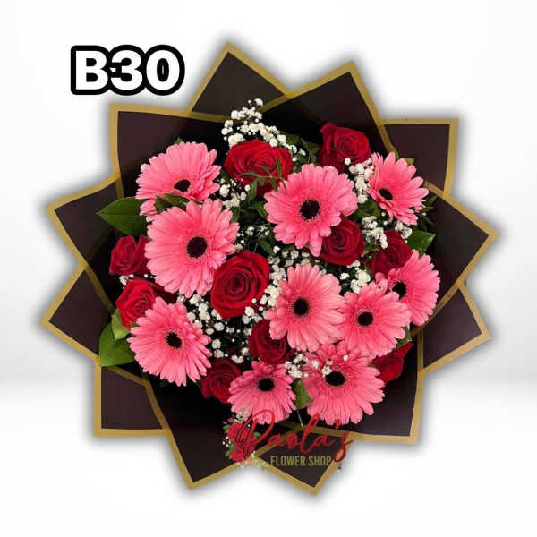 Pink gerbera daisies and red roses in a dark wrapped bouquet