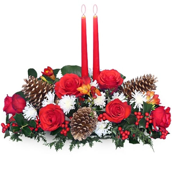 Low centerpiece of red roses, white mums, pinecones and berries with two tall red taper candles