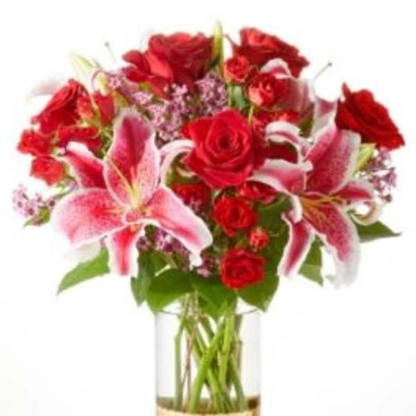 Bouquet of red roses and pink lilies in a gold vase