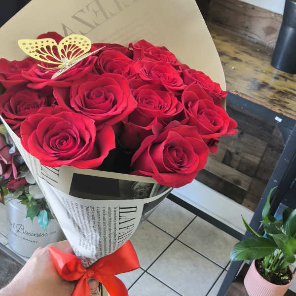 Bouquet of red roses wrapped in paper with a red ribbon