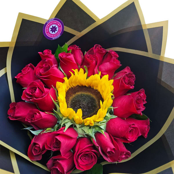 Bouquet of pink roses with a sunflower center wrapped in black paper