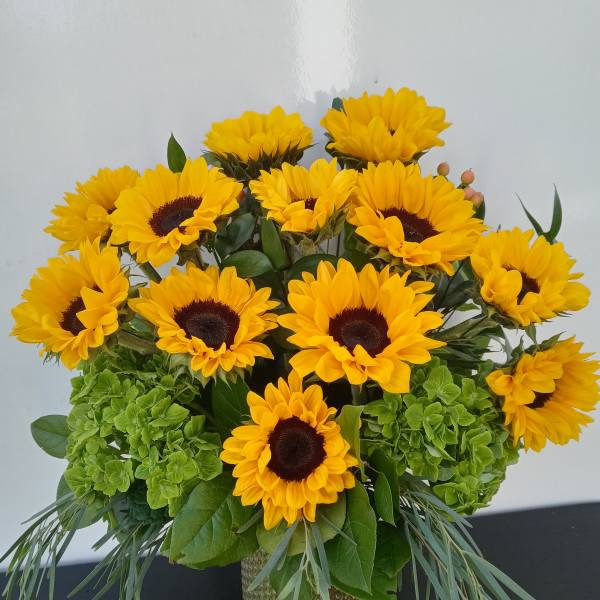 Bouquet of yellow sunflowers in a glass vase
