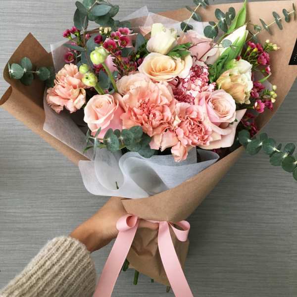 Hand-tied bouquet of blush roses and pink carnations with eucalyptus