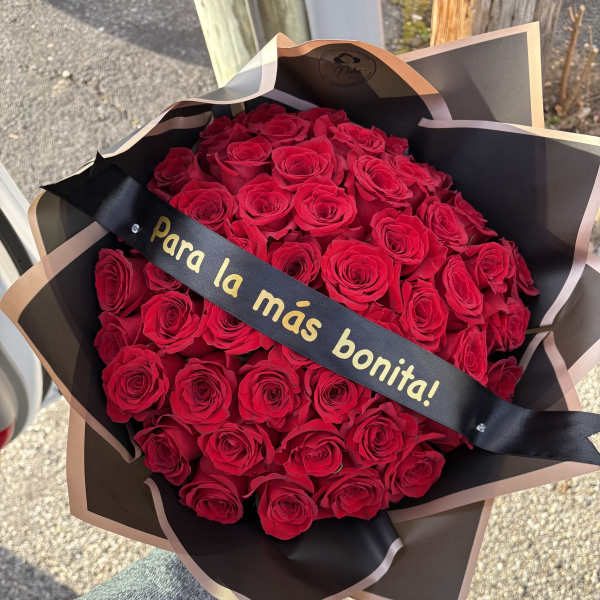 Bouquet of red roses wrapped in black paper with a ribbon