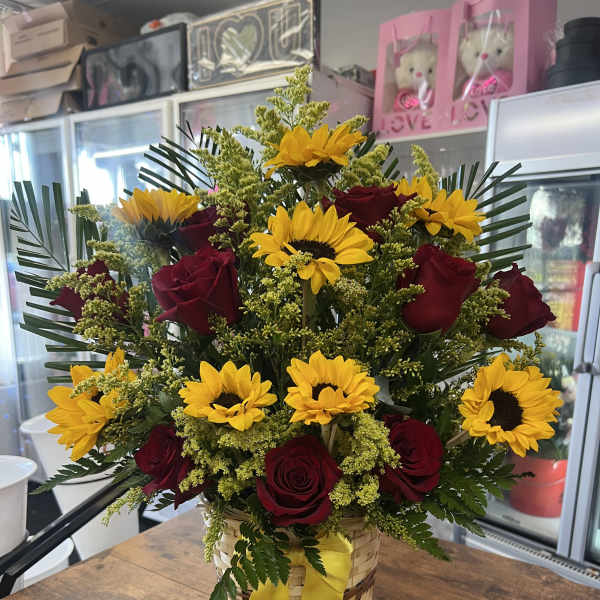 Basket arrangement of red roses and yellow sunflowers with a yellow ribbon