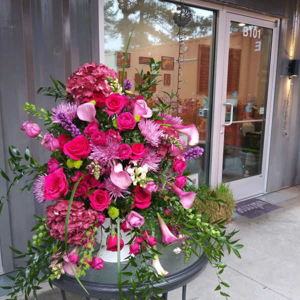 Large pink floral arrangement with roses, hydrangea, and calla lilies