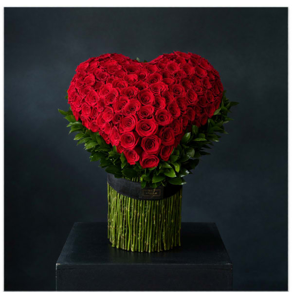 Heart-shaped red rose arrangement in a black container