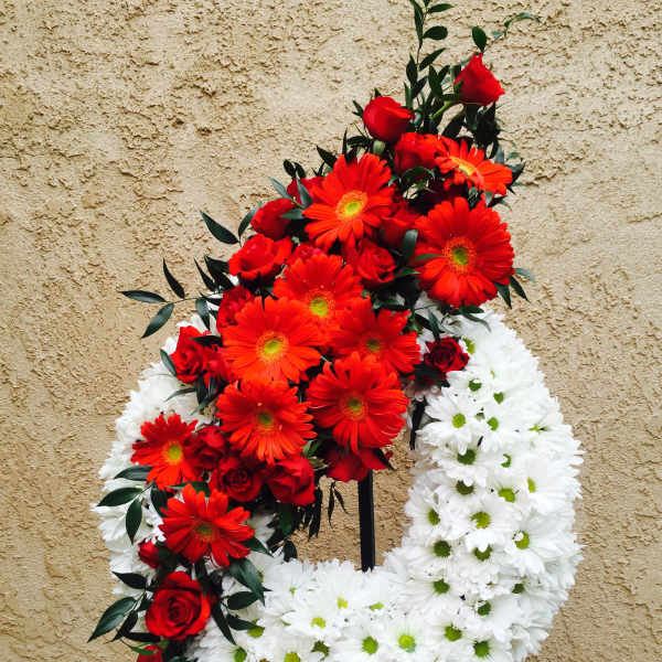 Red and white floral funeral wreath on a stand