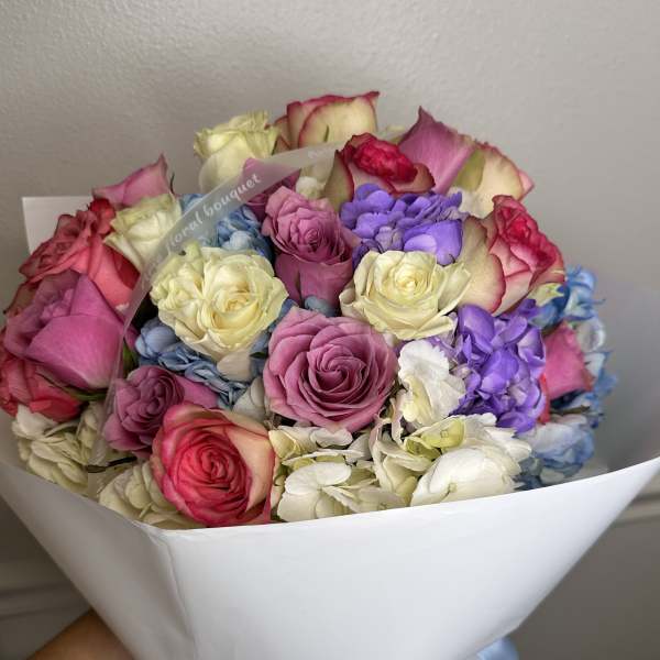 Bouquet of multicolored roses wrapped in white paper
