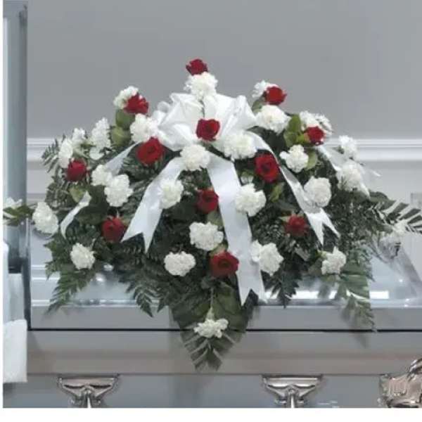Red and white floral casket spray with ribbon