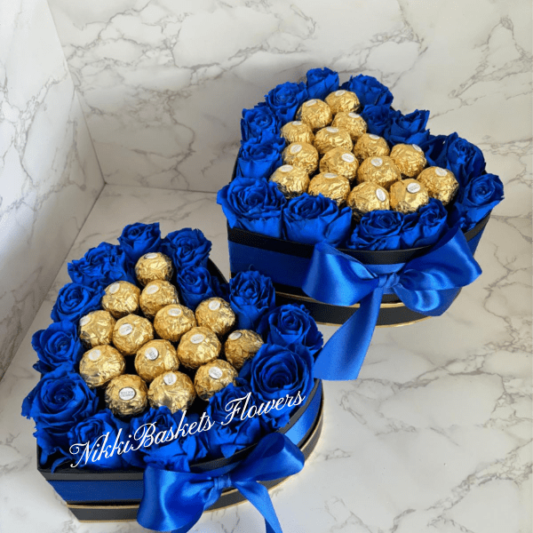 Two blue rose gift boxes filled with gold-wrapped chocolates and ribbon bows