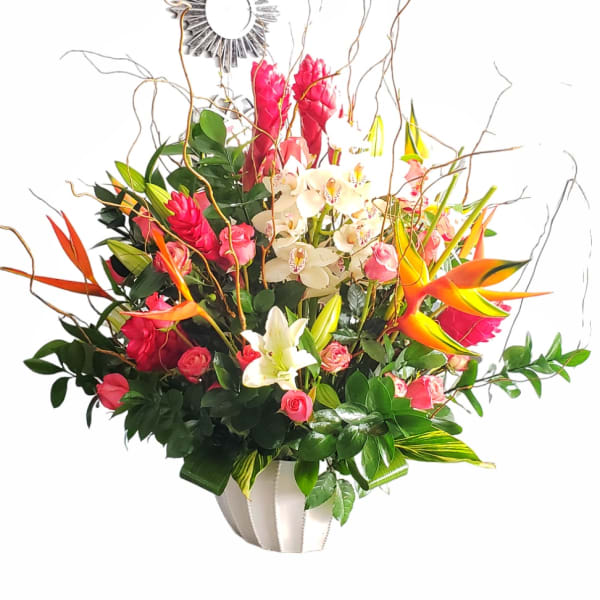 Tropical bouquet with pink orchids, roses, and orange bird-of-paradise in a white vase