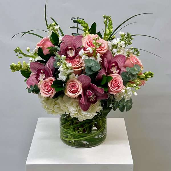 Pink roses and purple orchids in a glass vase