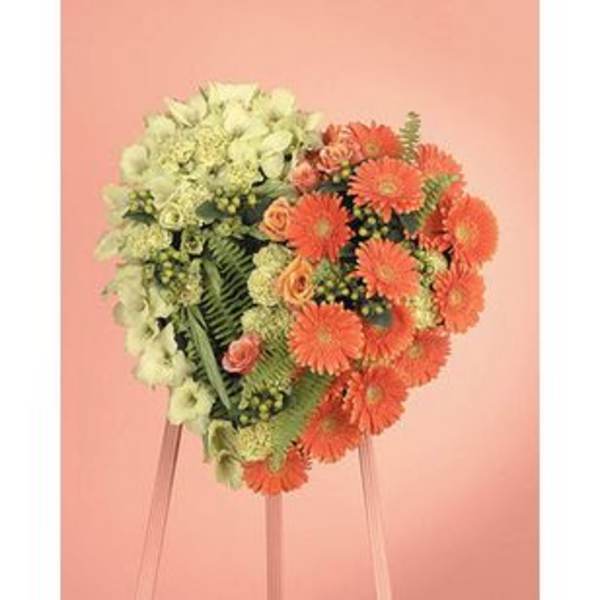Heart-shaped floral arrangement with orange and pale green flowers on a stand