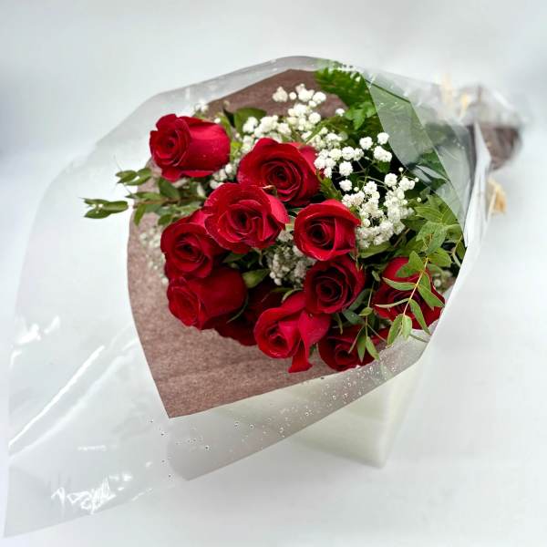 Bouquet of red roses with white baby's breath in clear wrap