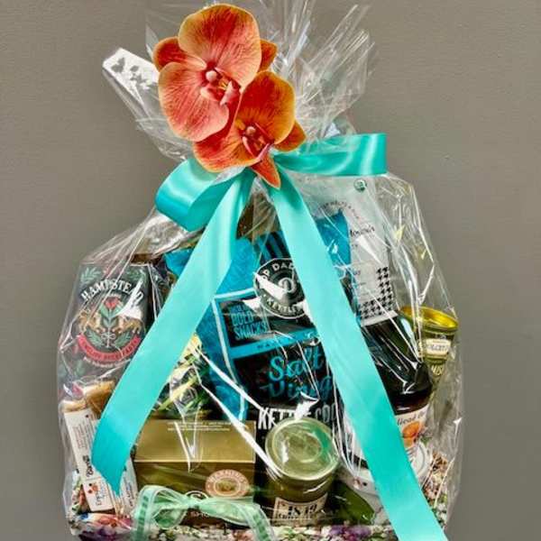 Gift basket wrapped in clear cellophane with a turquoise ribbon and orchid topper