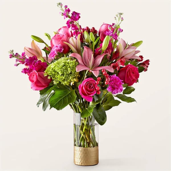 Pink and magenta flower arrangement in a clear glass vase
