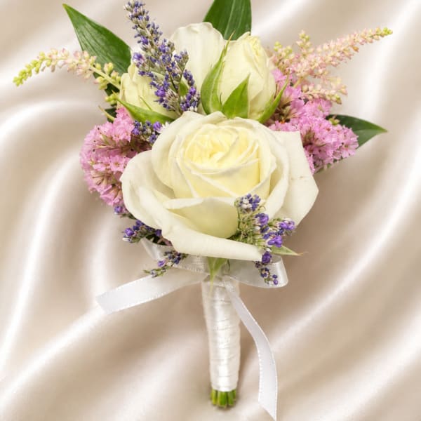 White rose boutonniere with purple and pink accent flowers
